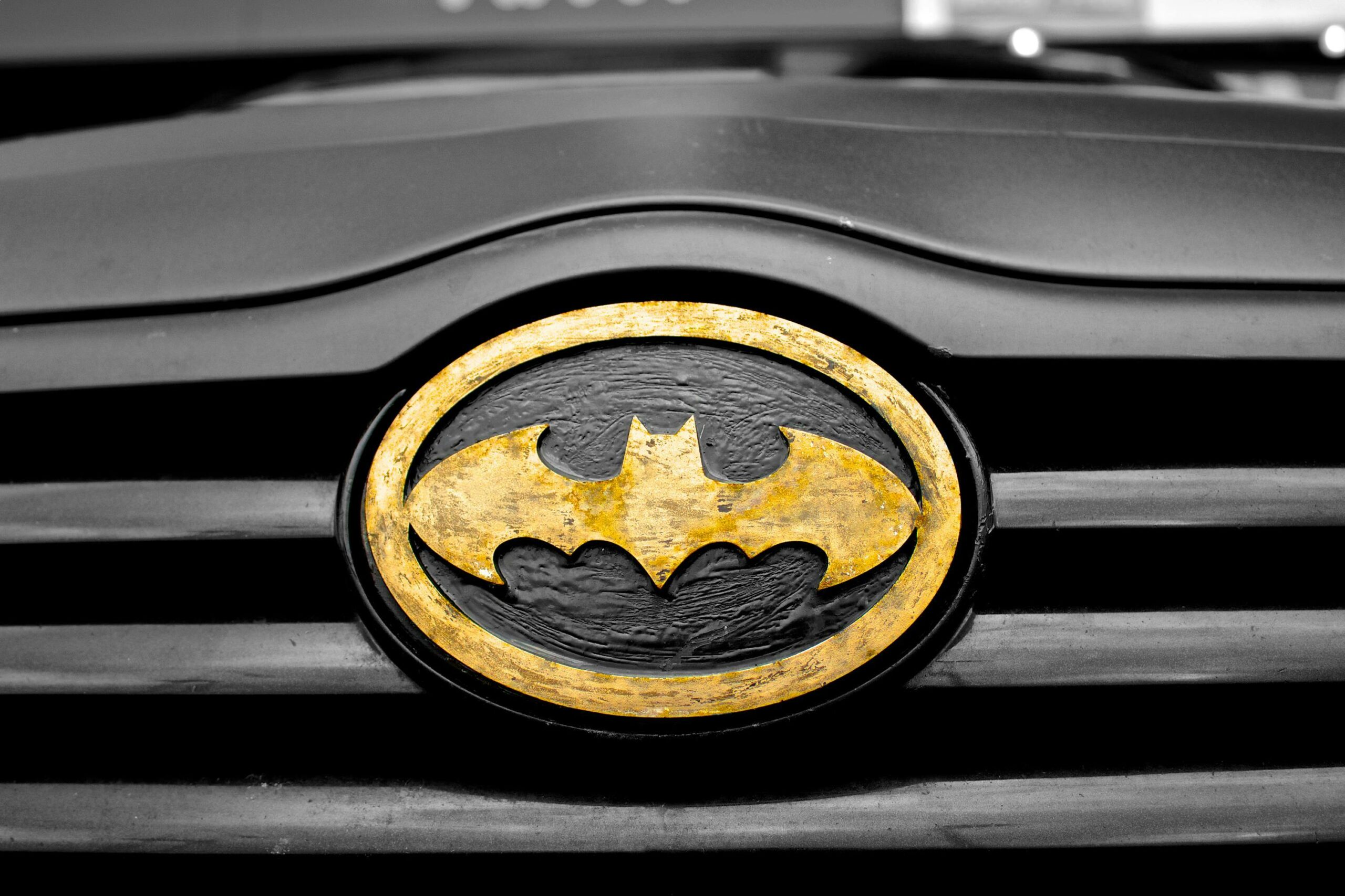 A detailed image of the iconic Batman logo on a car's grill, highlighting superhero symbolism.