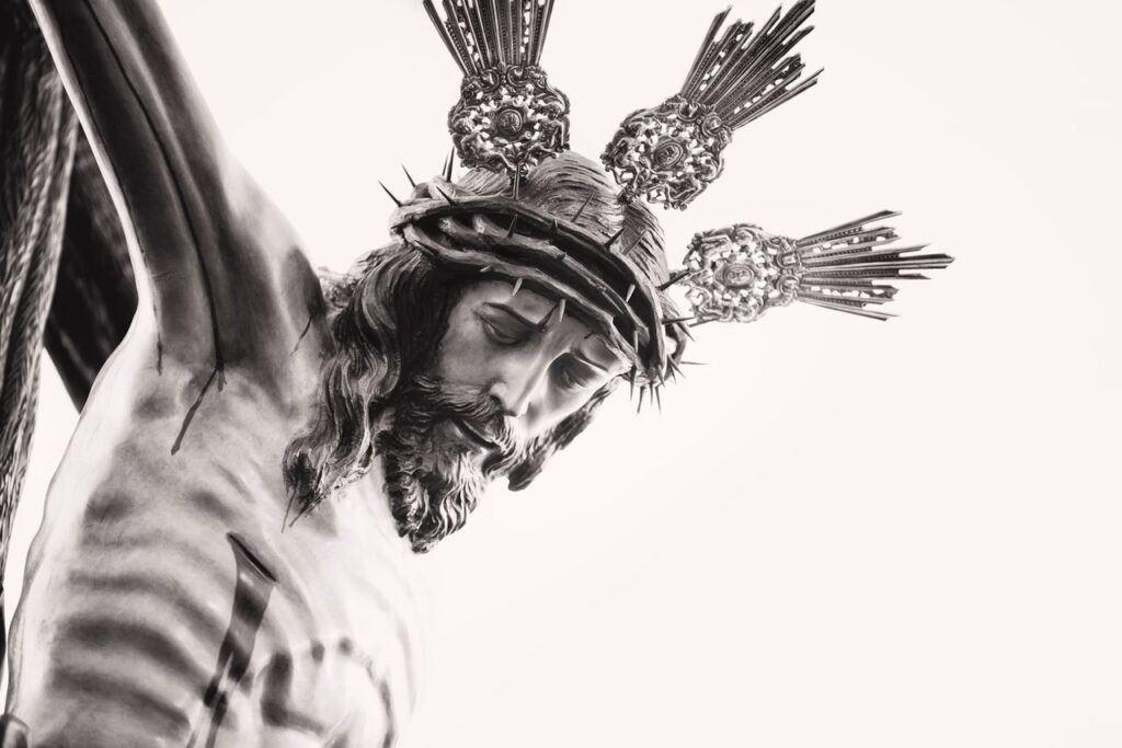 Fine art depiction of a crucifixion sculpture in black and white, highlighting religious symbolism.